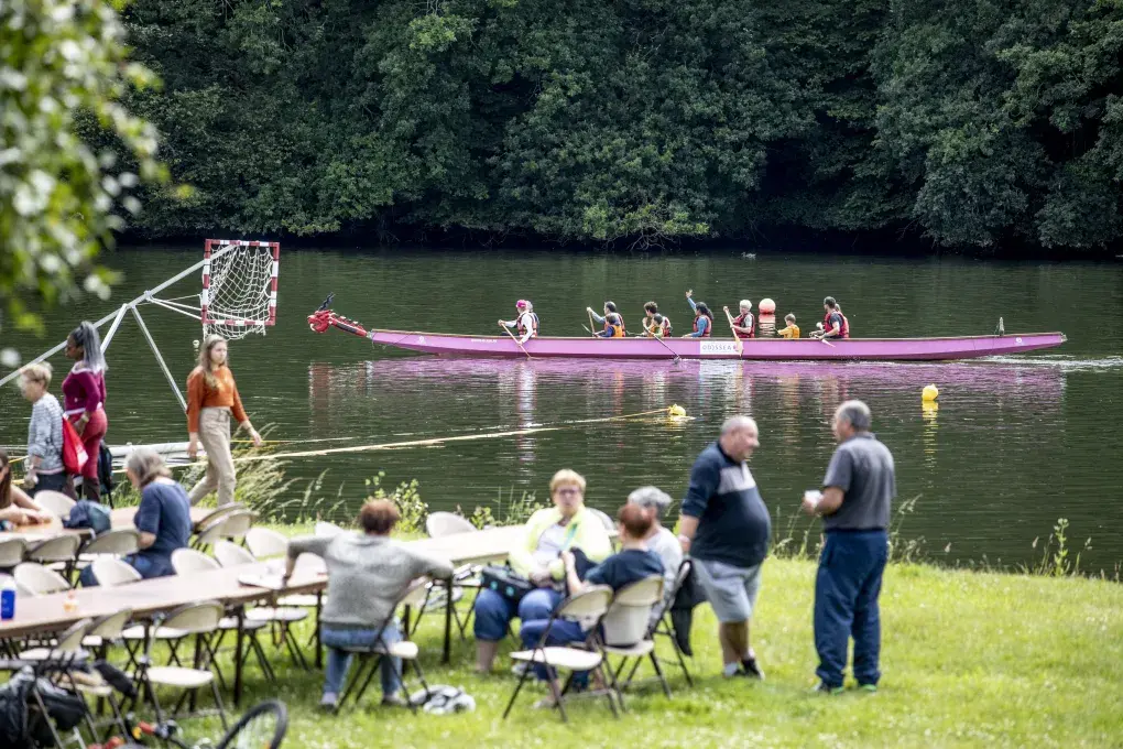 Des personnes au soleil au bord d'une rivière.