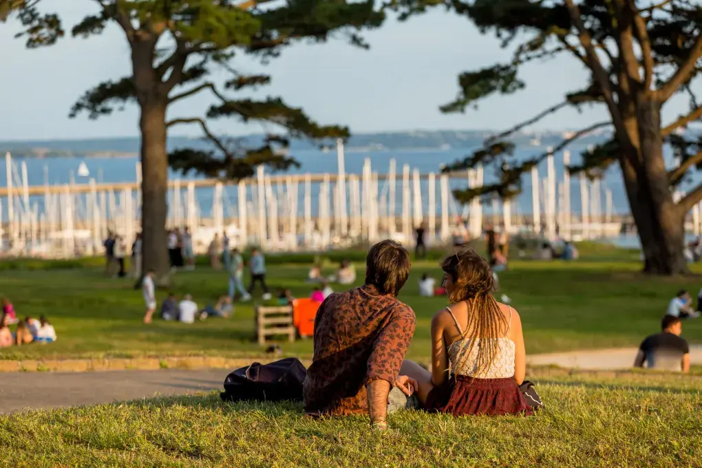 Deux personnes assises sur l'herbe sur l'esplanade du château