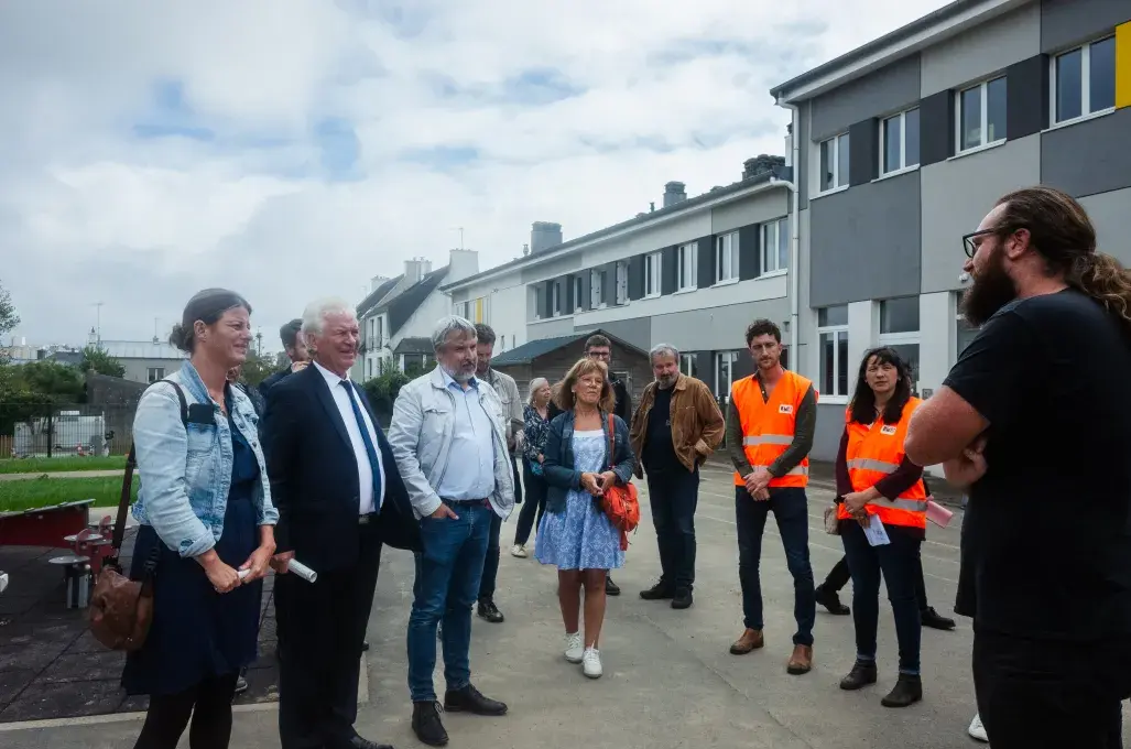 Plusieurs personnes visitent une école. 