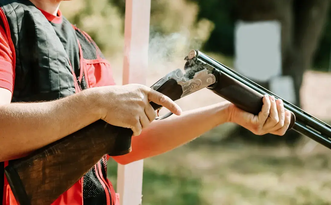 Un homme tient un fusil de chasse. 