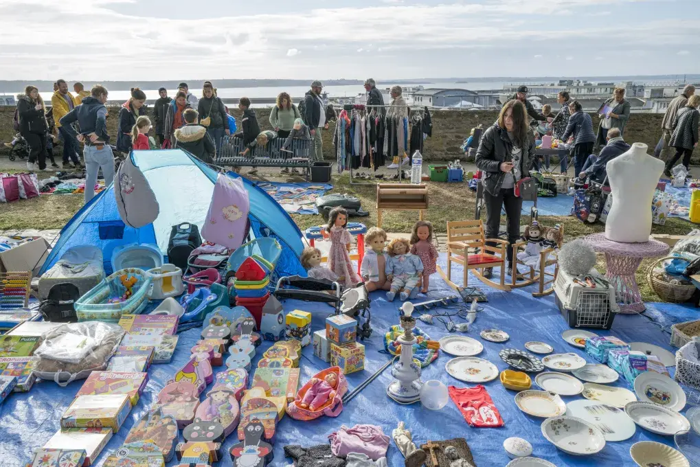 Des gens marchent à côté de petits stands.