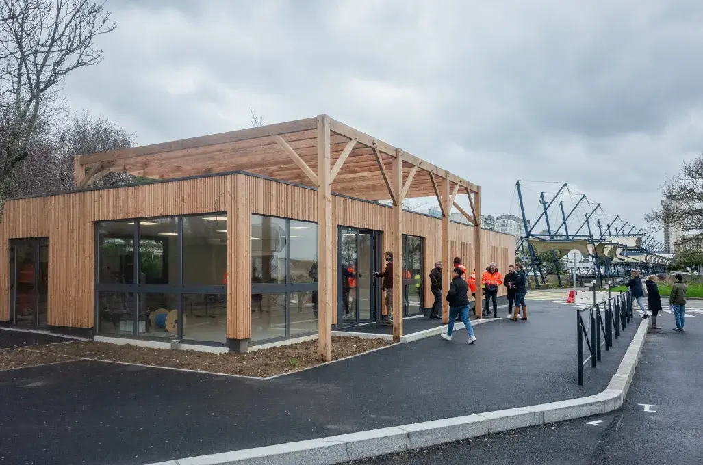 Des gens devant un bâtiment en bois.