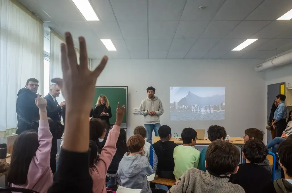 Des enfants lèvent la main dans une salle de classe.