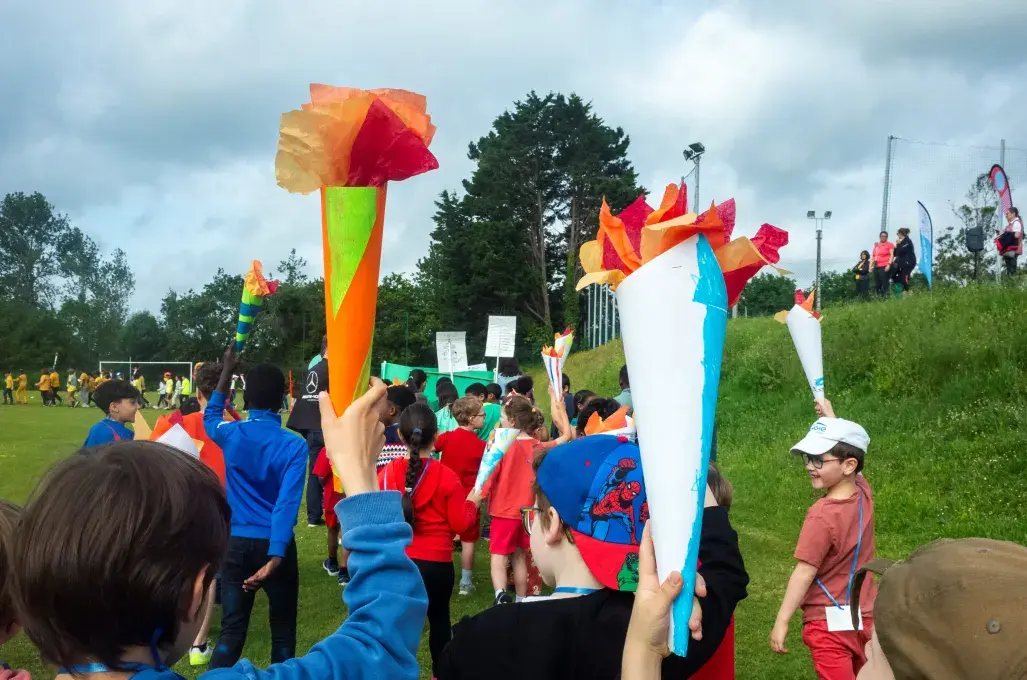 Des enfants tiennent une flamme olympique. 