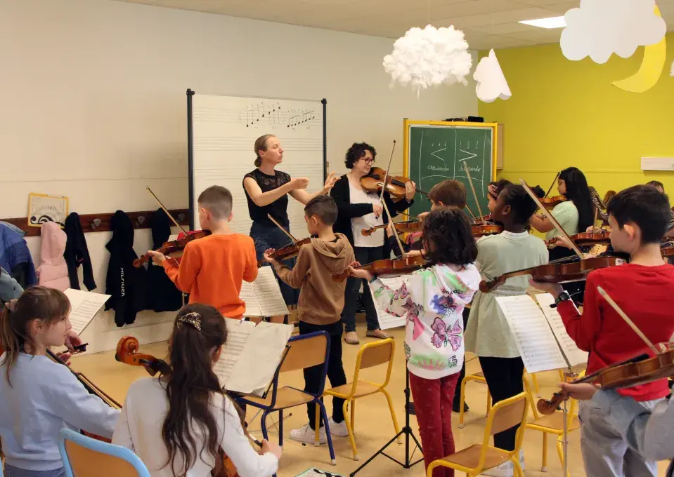 Des enfants jouant différents instruments de musique dans une classe 