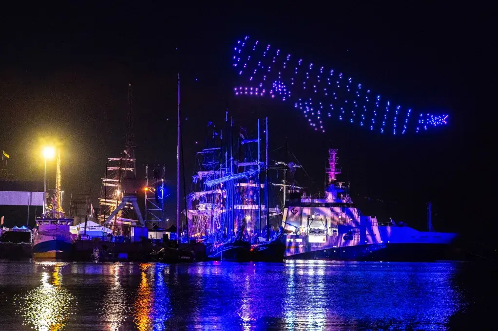 Vue e nuit sur des navires et le spectacle de drones