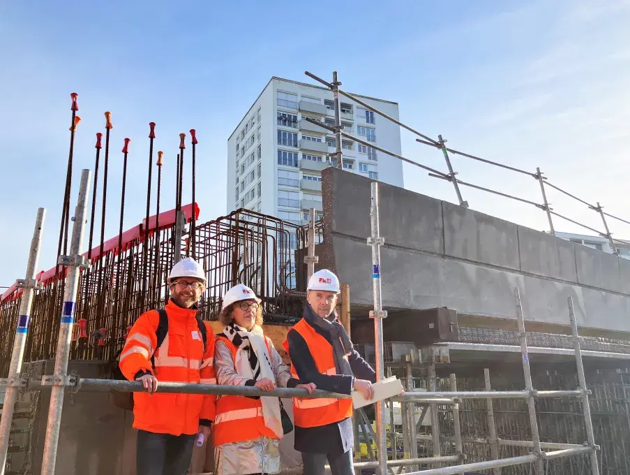 deux hommes et une femme en tenue de chantier au pied du futur pont de Kergoat