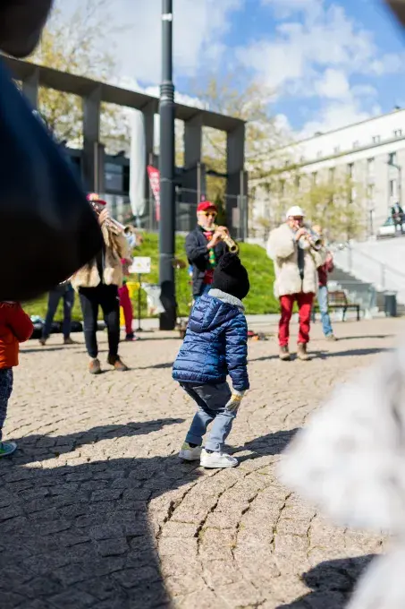 Un enfant danse devant des musiciens.