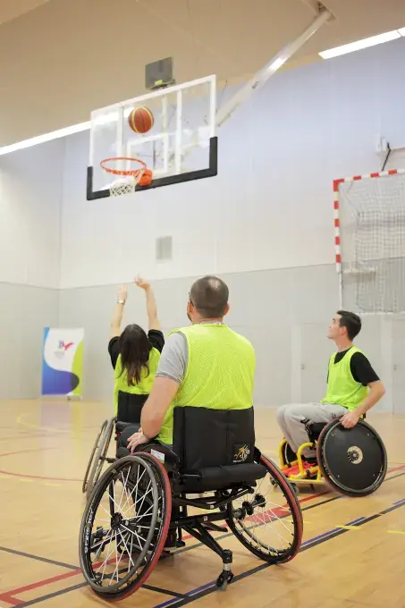 Des personnes en fauteuil roulant jouent au basket.