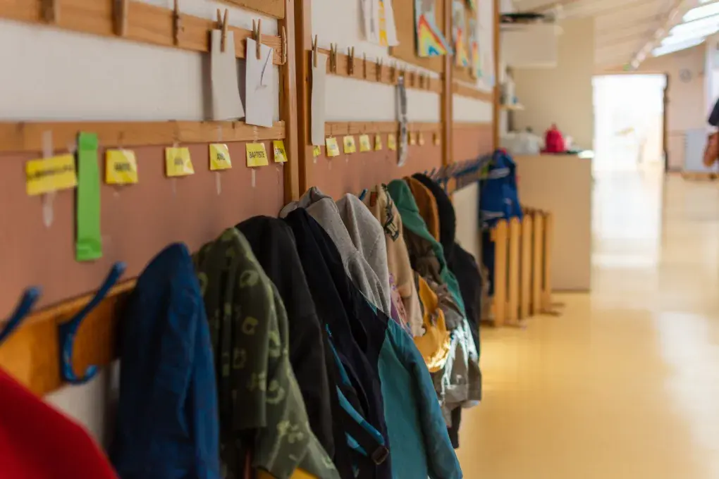 couloir d'une école avec des manteaux d'enfants accrochés au mur