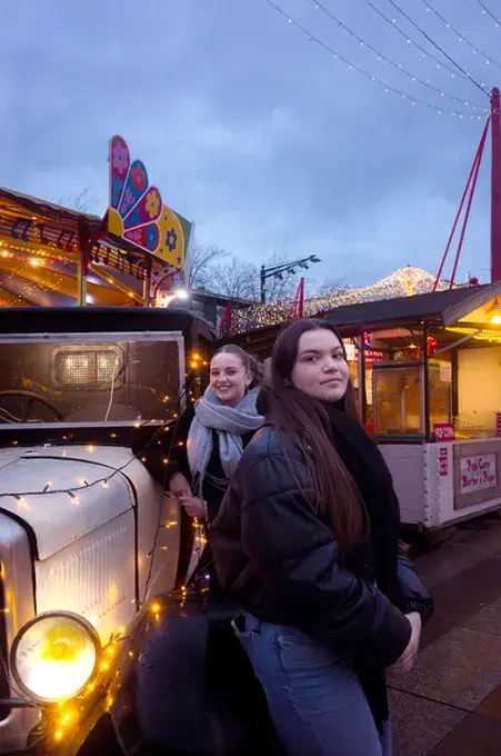 Deux jeunes femmes posant au marché de Noël
