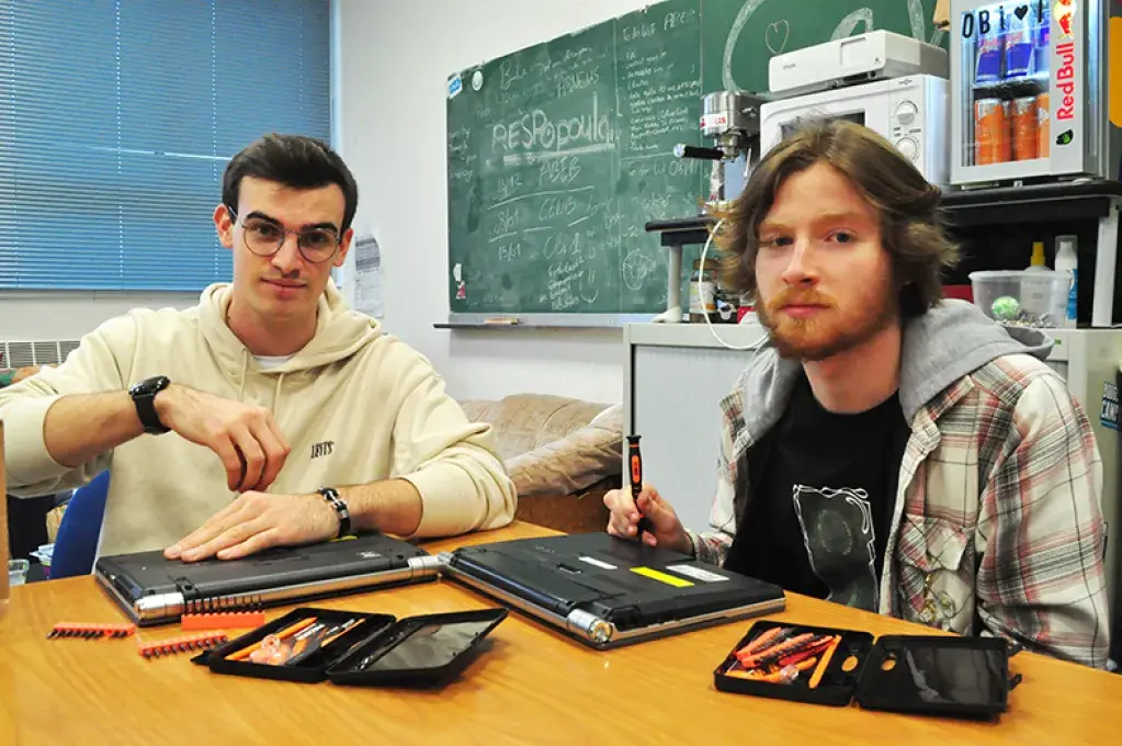 Deux jeunes hommes devant des ordinateurs