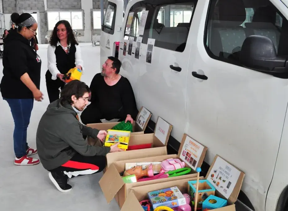 Des personnes trient des jouets dans un entrepôt