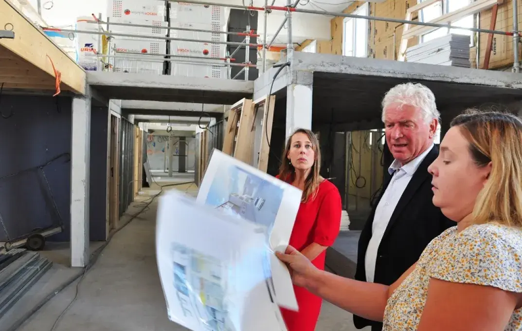 Deux femmes et un homme visitent le chantier de réhabilitation du CCAS