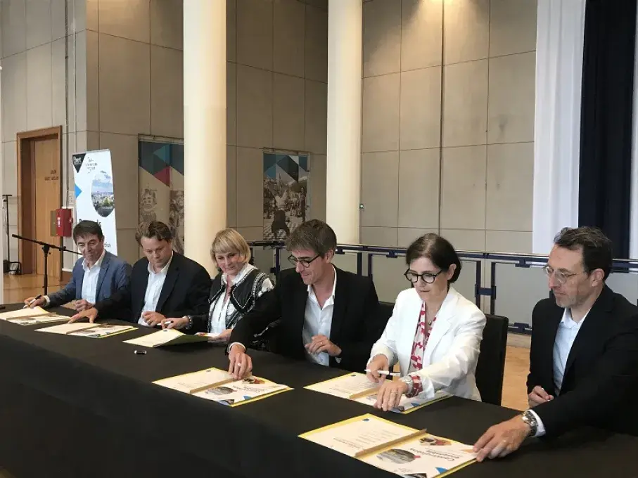 Des hommes et des femmes signent une convention à l'hôtel de ville de Brest