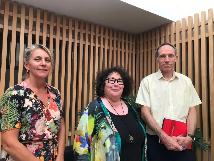 deux femmes et un homme posent devant l'objectif