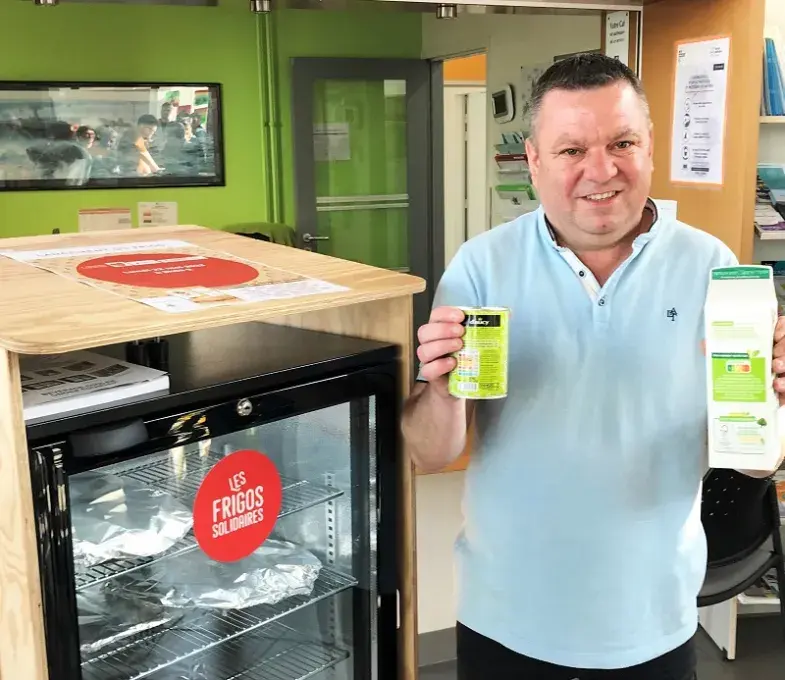 Un homme pose à côté du premier frigo solidaire, à la maison de quartier de Lambézellec