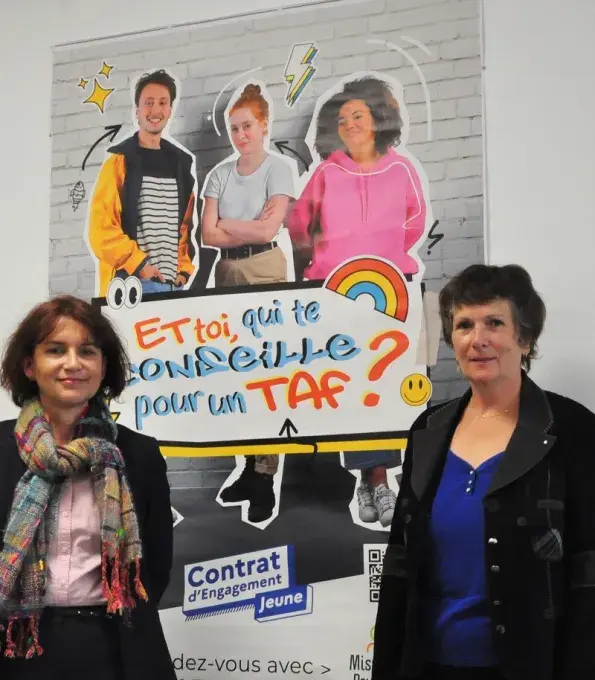 Deux femmes posent autour d'une affiche de la Mission locale du Pays de Brest.
