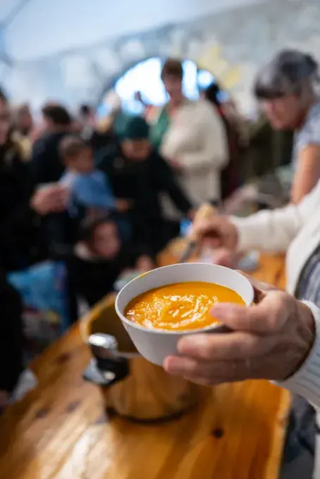 Un bol de soupe tendu vers l'objectif