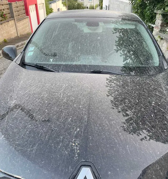 Le capot d'une voiture touchée par le nuage de sable du sahara