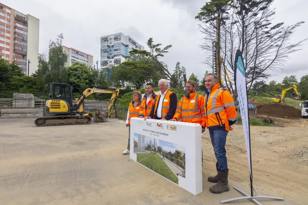 Plusieurs personnes posent devant un mur.