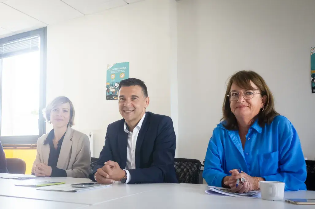 Trois personnes assises à une table.