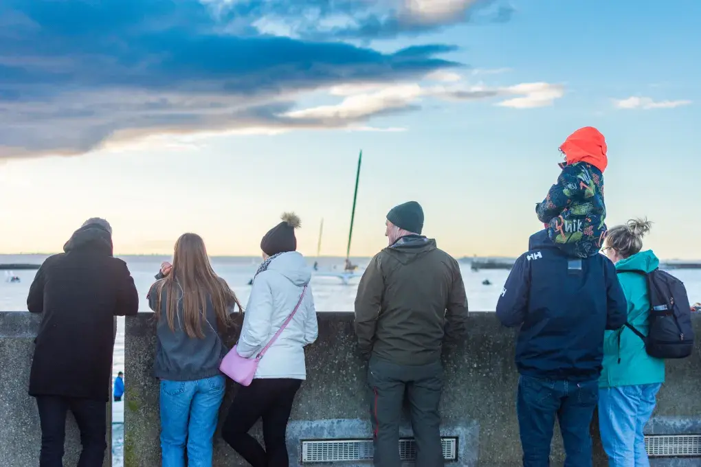 Des gens regardent un bateau partir.
