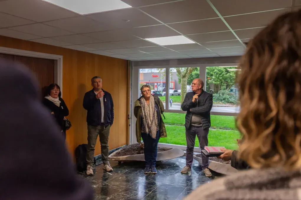 Plusieurs personnes dans un hall d'immeuble.
