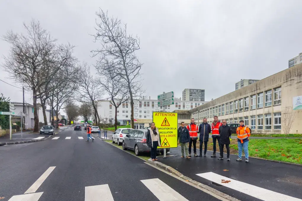 Plusieurs personnes posent dans une rue.