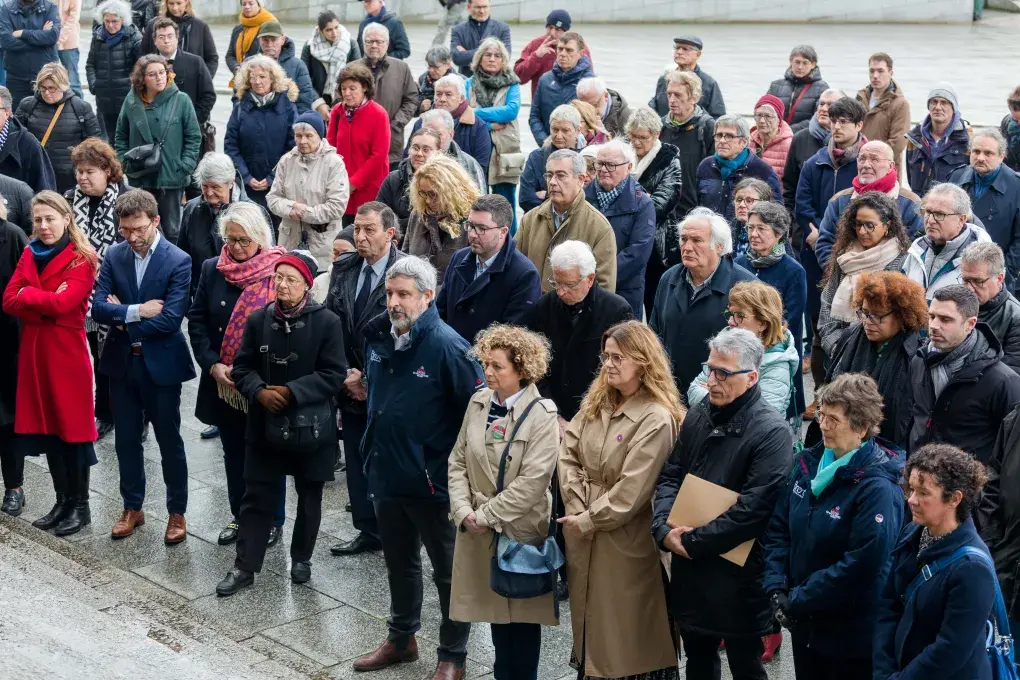Des hommes et des femmes recueillis sur la place de la Liberté