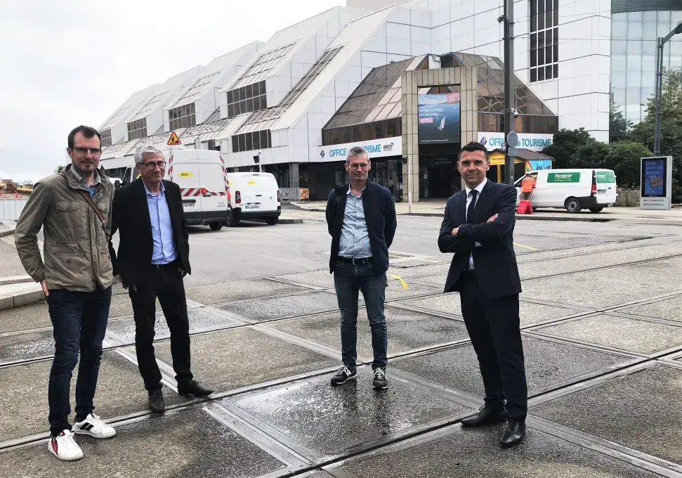 Quatre hommes posent au niveau de la ligne de tramway, avenue Clemenceau