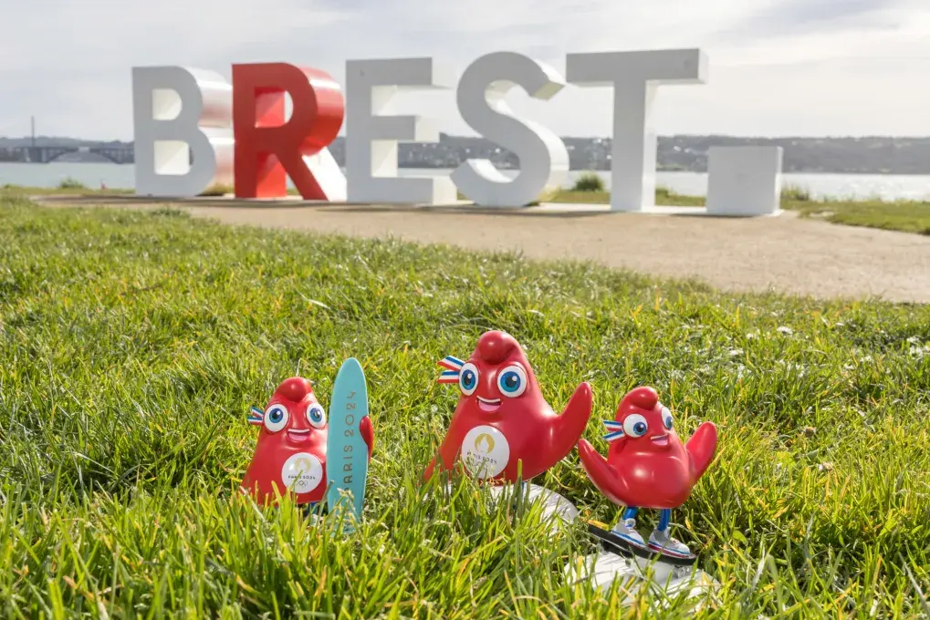 Des figurines dans l'herbe devant la mer