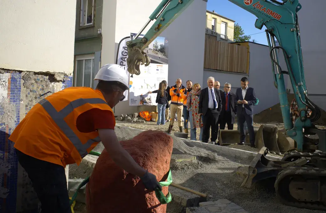 Un travailleur du bâtiment enlevant un sangle autour d'une pierre