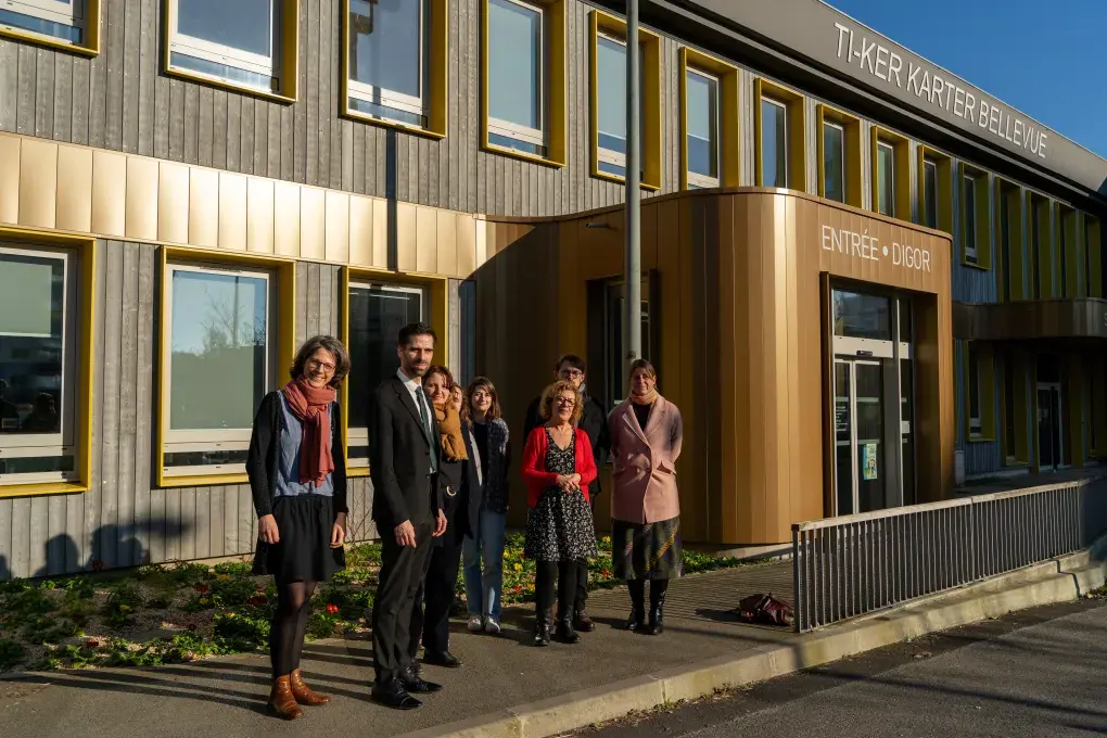 Plusieurs personnes devant un bâtiment.