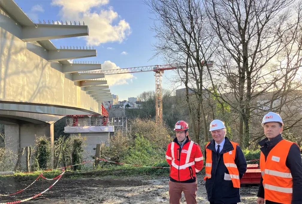 Trois hommes posent devant la pose du tablier du nouveau pont Schuman