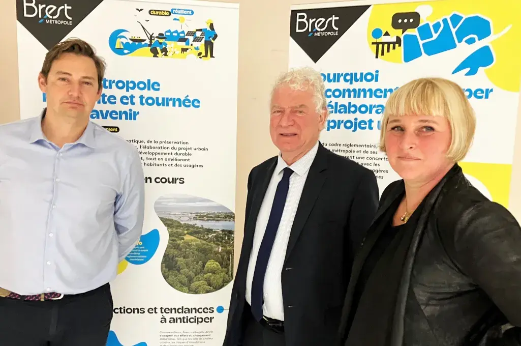 deux hommes et une femme regardent l'objectif