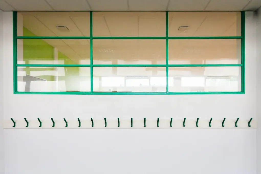 Des porte-manteaux vides dans un couloir.