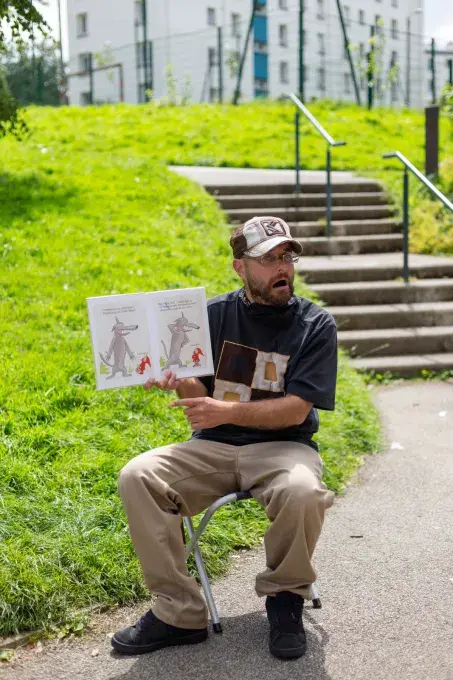 Un homme lit un livre au pied d'une tour.