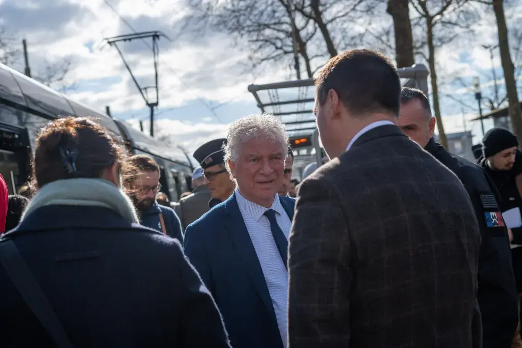 Plusieurs personnes devant un tramway.