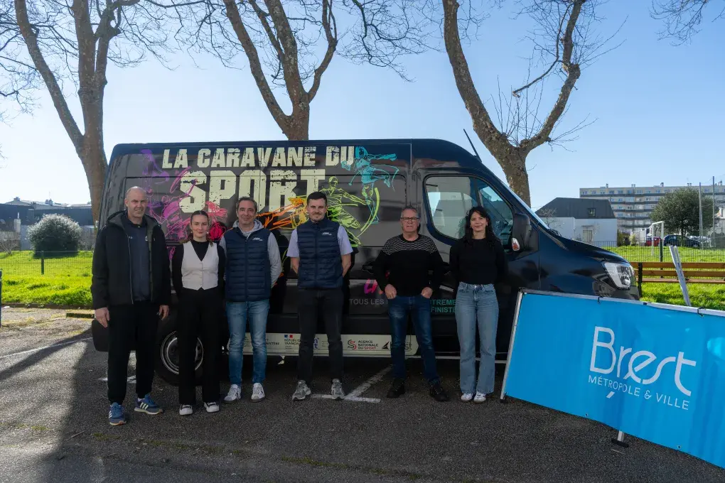 Plusieurs personnes devant un stade de foot.