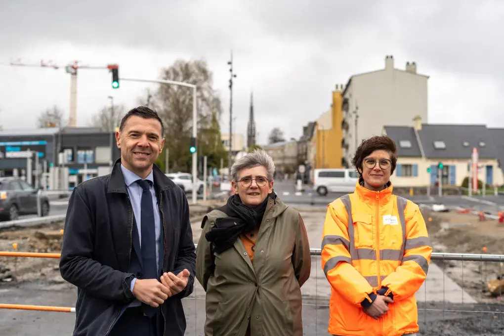 Trois personnes devant un chantier.