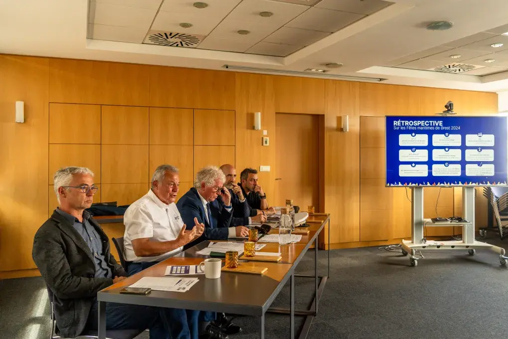 Plusieurs personnes assises à un bureau.