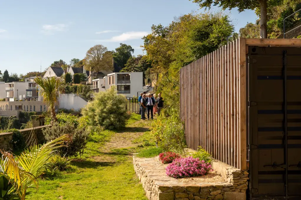 Des personnes marchent dans un jardin. 
