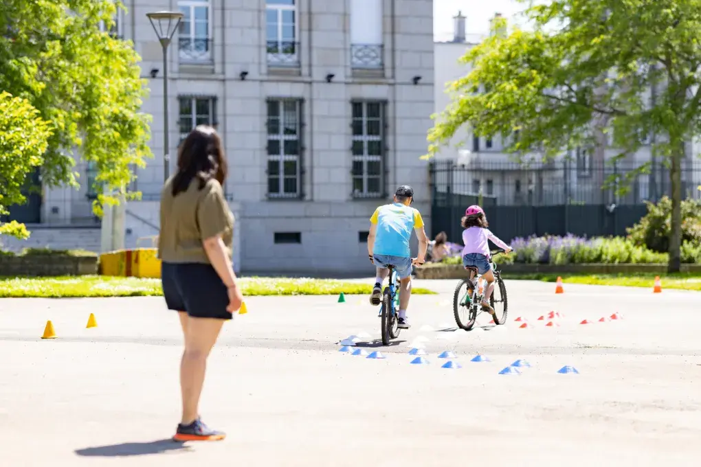 Une enfant roule à vélo.