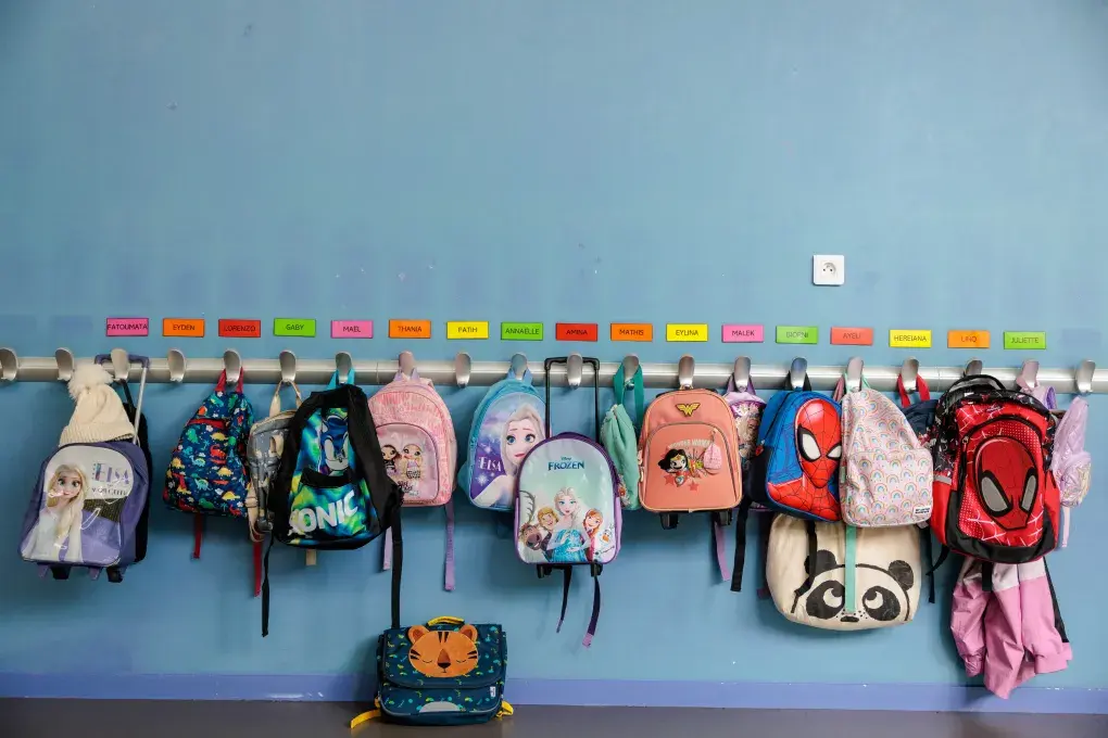 des sacs d'enfants accrochés au porte-manteaux, dans une école