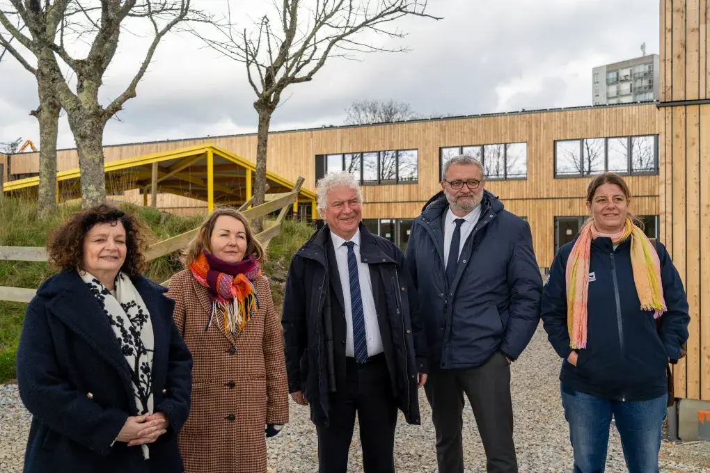 Plusieurs personnes devant un bâtiment en travaux.
