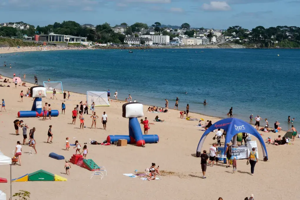des personnes sur la plage du moulin blanc et dans l'eau