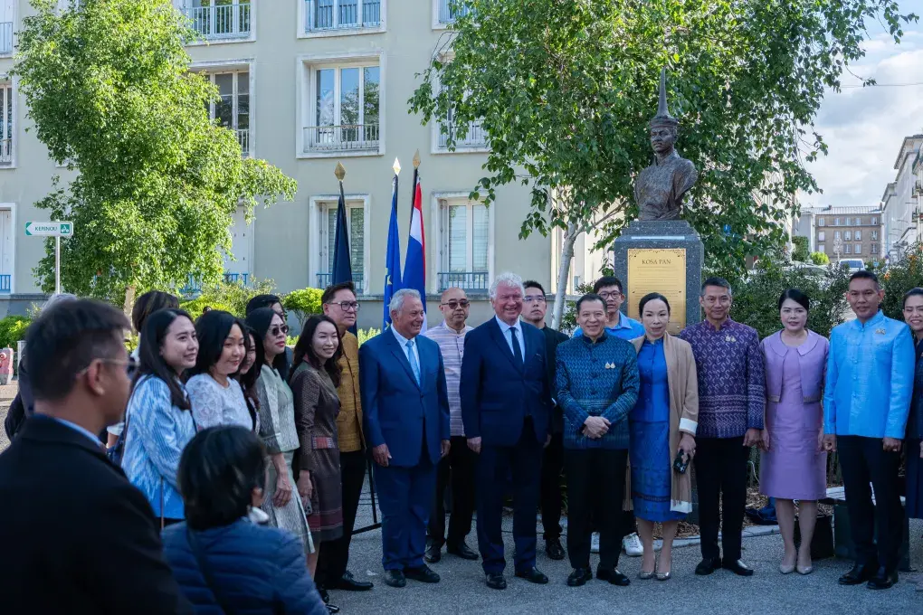 Plusieurs personnes devant une statue.