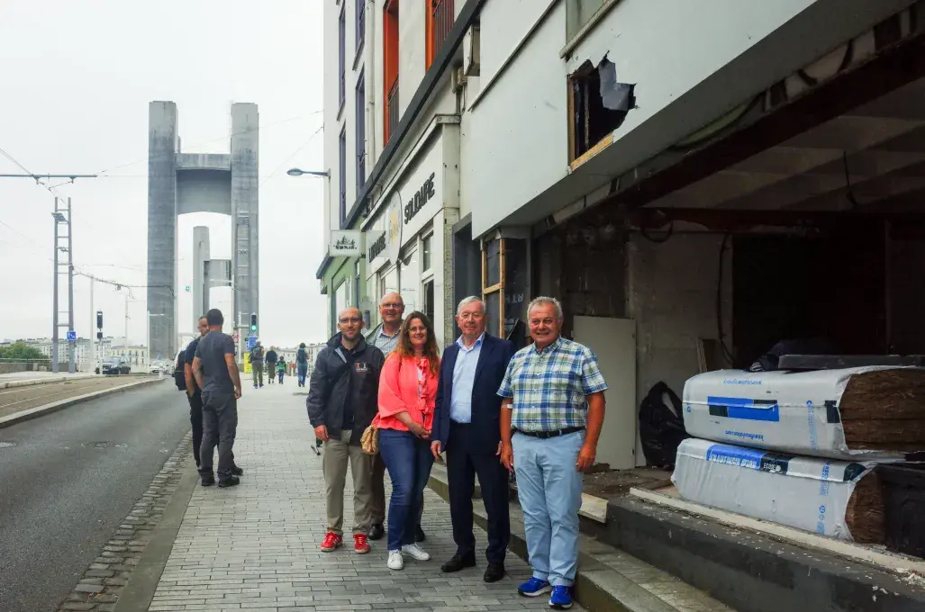 Des personnes devant un bâtiment en travaux.