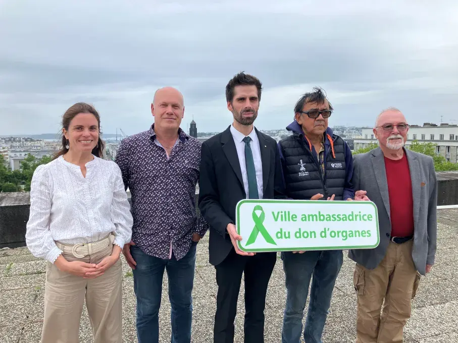 Des hommes et des femmes portant la plaque Ville ambassadrice du don d'organes